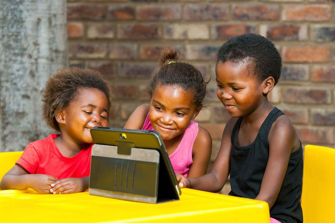 3 African girls staring a tablet