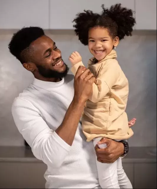 Black Father holding daughter 