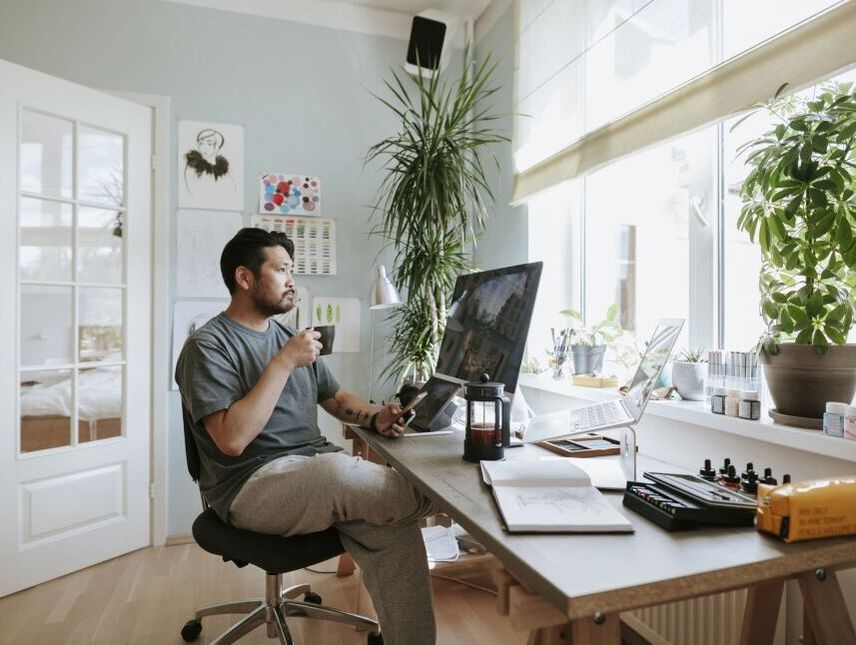 Home office with a man sitting and starring at a screen