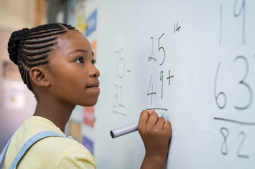 Black Girl doing math on the board