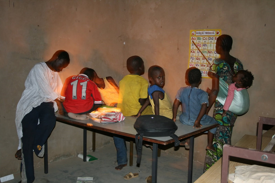 children sitting on a table with a teacher